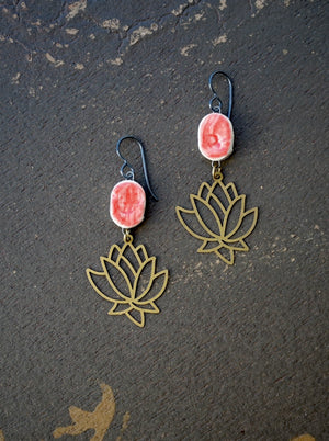 a pair of earrings with pink flowers on them