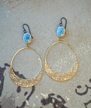 a pair of gold hoop earrings with blue beads