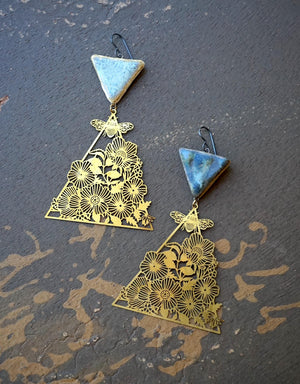 a pair of gold and blue triangle shaped earrings