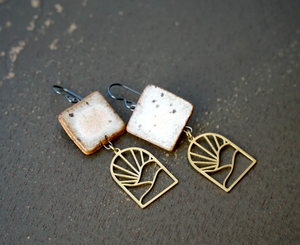 a pair of earrings sitting on top of a floor