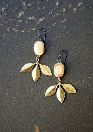 a pair of earrings with leaves hanging from them