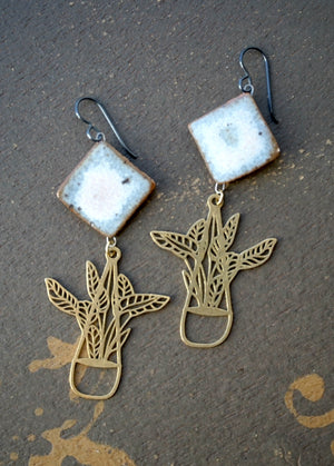 a pair of earrings with a bird and flower design